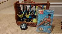 Photo showing EastPoint lawn darts in wooden caddy with two target rings and NHL Maple Leafs hockey puck in front.
