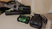 Leaf blower with detached tube, battery and charger laid out