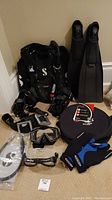 Overall lot arranged showing BCD, fins, masks, weight belt, gloves, and storage bag