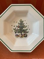 Top-down view of the large octagonal bowl showing the Christmas tree design with presents, teddy bear, and stars, and green trim around the rim.