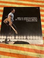 Front cover of the box showing Bruce Springsteen holding a guitar on stage, with the title 'Bruce Springsteen & The E Street Band Live 1975-85', indicating it is a 5 LP set.