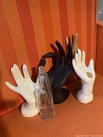 Five hand mannequins arranged closely showing different materials and poses including china, wood, plastic, and glass.