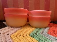 Set of 4 orange gradient Fire King ramekin bowls stacked 2x2 showing exterior color and shape.