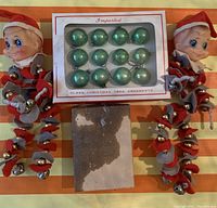 Overview of two vintage elf figurines, one box of 12 green glass ornaments, and the box bottom.