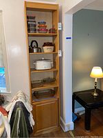 Full view of the wood bookcase with items on the shelves and the enclosed cabinet at the bottom.