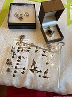 Photo showing the ring and earrings with purple stones, the chain, and the pendant in its case.