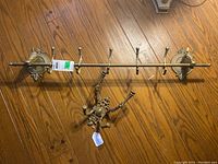 Full view of the metal wall rack with six hooks and horse head mounts, showing length and style.
