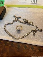 Chain and ring displayed together on white cloth
