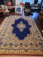 Full view of blue oriental area rug on hardwood floor with surrounding furniture