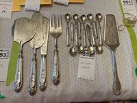 Overhead view of all utensils: two flat servers, serving fork, group of small spoons and pie server