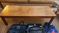 Full top-down view of a rectangular wooden coffee table showing wear and some dark stains on the surface.