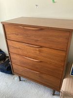 Front view of dresser showing four full-width drawers and integrated curved handles