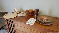Overview of all items on furniture including wooden salad set, salt and pepper shakers, decorative plates and dish.