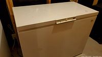 Front view of a white Kenmore chest freezer showing lid and locking mechanism.
