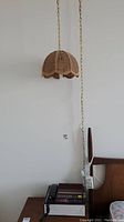 Full view of swag hanging lamp suspended on chain above Pulsar phone alarm radio unit on wooden surface.