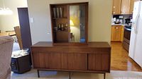 Straight-on front view showing entire cabinet with upper glass display and lower storage section.
