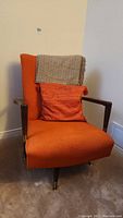 Front left three-quarter view showing chair with pillow and blanket