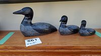 Full view of family of three soapstone loon sculptures, showing size differences and details