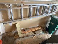 Full view of seven foot aluminum stepladder leaning against a wall.