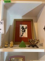 Shelf display showing all items including framed horse picture, jade Buddha, two cat figurines, and stone candle holder.