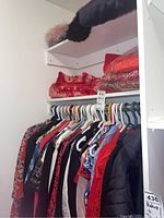 Closet hanging with various women's coats, jackets, vests, and scarves in assorted colors and patterns