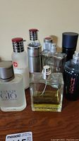 Wide view of all 7 cologne bottles showing front and some label details