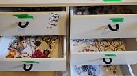 Five open drawers showing a mix of costume jewelry including earrings, necklaces, and jewelry bags