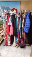 Rack of various dresses and hats showing range and variety including traditional Chinese style dresses, sequined and glittery dresses.