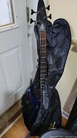 Full view of the electric bass guitar with the padded carrying bag showing the body and neck.