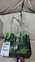 Top and side view of clear crystal sculpture depicting two birds on a branch, placed on original Mats Jonasson box with forest imagery and branding label.