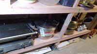 Wide shelf view showing Breville panini press, Zebra pot, and multiple dishes with lids.