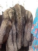 Full front view of raccoon fur coat on hanger