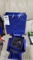 Blue Swarovski shopping bag with tag showing lot number and brand name