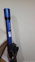 Blue Meade Instruments refractor telescope tube mounted on an adjustable tripod stand, showing the upper portion and focusing controls.