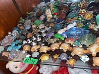 Display case with a variety of turtle figurines of different materials and colors