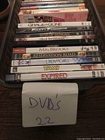 Photo of 22 DVD movies stacked showing titles and DVD cases.