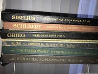 Photo of album booklets stacked showing titles by Sibelius, Schubert, Grieg, Mozart, Tchaikovsky, and Strauss Johann.