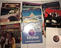 Collection of vinyl records stacked showing various album covers featuring Earth, Wind & Fire, George Duke, Herb Alpert, and others.