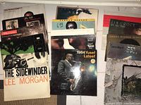 15 vinyl record albums stacked and arranged, showing covers of jazz and soul artists including Lee Morgan, George Benson, Ralph MacDonald, Hugh Masekela, Yusef Lateef, Jim Croce, Charles Mingus, and Sarah Vaughan.