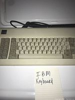 Top view of vintage IBM keyboard showing beige keys and IBM label on corner with a handwritten note 'IBM Keyboard'