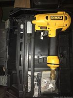 Top view of DEWALT pneumatic nailer inside black hard carrying case.