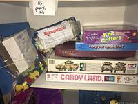 Photo showing assorted boxes including Rummikub, Scrabble, Knit Critters kit, Design Your Own Plate set, M3 Bradley CFV model kit, Candy Land Pooh edition.