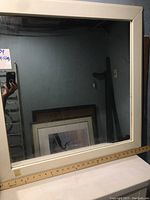 Square white frame mirror with measuring ruler indicating 29.5 inches size.