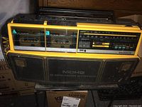 Front view of yellow and black Magnavox MDHQ 5 Speaker System boom box featuring dual cassette decks and radio tuner