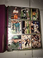 Photo of football cards featuring players and coaches from Pro Set, in clear plastic album sleeve within binder