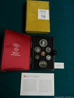 Photo showing the set of 7 coins in black Royal Canadian Mint case with red interior, certificate and box included.
