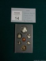 Photo showing the face side of seven coins in a plastic mint packaging, including the commemorative double dollar coin featuring a mounted figure.