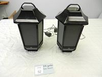Pair of AR Audio Research portable outdoor Bluetooth speakers with handles, black lantern style, standing upright on table.