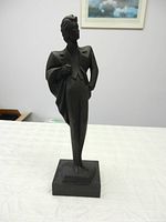 Front view of black Art Deco man in tuxedo sculpture on square base.