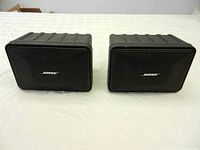 Pair of Bose Model 101 speakers front view showing black metal grille and Bose logo.